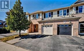 Oakville (Bc Bronte Creek) townhouse for rent - A house with a garage and a tree in front of it.
