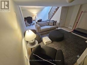 Oakville (Bc Bronte Creek) townhouse for rent - A living room with a couch, ottoman, and lamp.