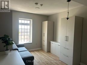 Oshawa (Central) condo for rent - A realtor photo of a bedroom with a window, a bed, and a potted plant.