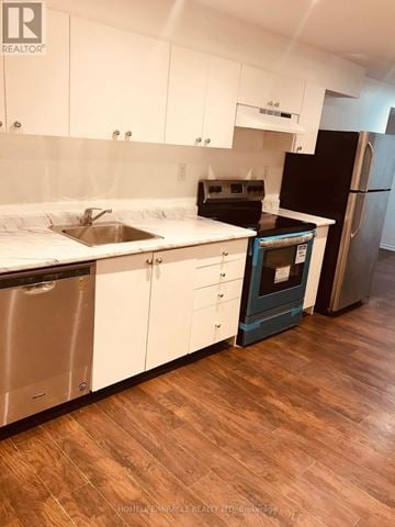 Mississauga (Central Erin Mills) apartment for rent - A kitchen with white cabinets and a black oven.