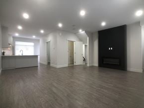 Surrey townhouse for rent - A spacious living room with a fireplace and a kitchen area.