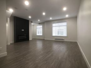Surrey townhouse for rent - A spacious room with wood flooring and a fireplace.