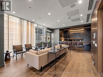 Toronto (Mimico) condo for rent - A modern living room with a large sectional sofa and a kitchen area in the background.