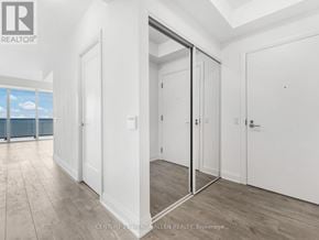 Toronto (Mimico) condo for rent - A real estate image of a white room with a glass door leading to a balcony.
