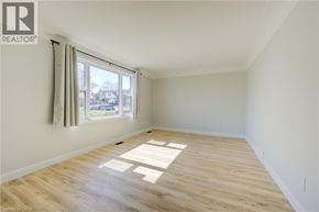 Kitchener apartment for rent - A room with wooden flooring and a window with curtains.