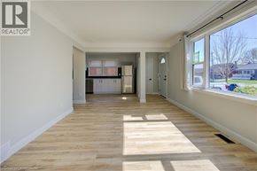 Kitchener apartment for rent - A spacious room with wooden flooring and white walls.