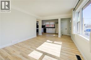 Kitchener apartment for rent - A spacious room with wooden flooring and white walls.
