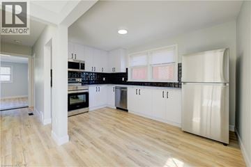 Kitchener apartment for rent - A kitchen with white cabinets and a wooden floor.
