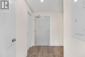 Welland (Broadway) condo for rent - A white door with a silver handle is in a room with white walls.
