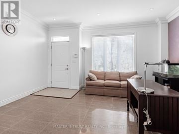 Markham (Commerce Valley) townhouse for rent - A living room with a brown couch and a white door.