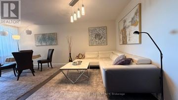 Mississauga (Lakeview) condo for rent - A living room with a white couch, a coffee table, and a painting on the wall.