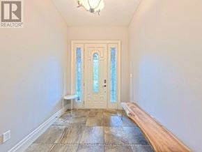 Waterloo townhouse for rent - A hallway with a bench and a door with a glass panel.