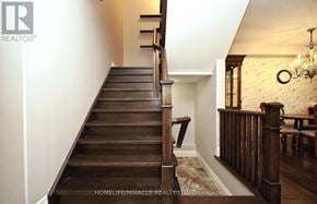 Waterloo townhouse for rent - A wooden staircase with a chandelier in the background.