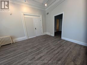 London East (East K) multi-family for rent - A room with a wooden floor and white walls, with a door and a window.