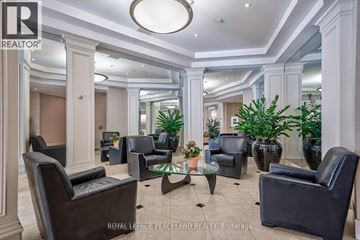 Toronto (Niagara) condo for rent - A spacious living room with black leather chairs and a glass coffee table.