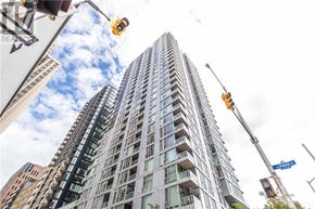 Ottawa apartment for rent - A tall building with many windows is being cleaned by a worker on a platform.