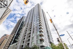 Ottawa apartment for rent - A tall building with many windows is under a blue sky with clouds.