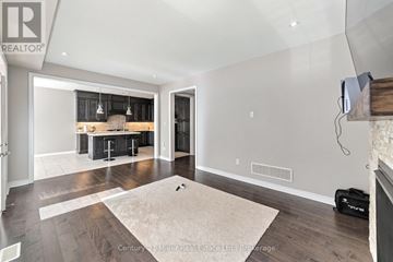 Oakville (Go Glenorchy) apartment for rent - A living room with a rug in the middle and a kitchen area in the background.