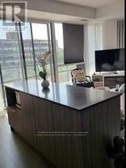 Toronto (Banbury-Don Mills) condo for rent - A modern living room with a wooden cabinet and a flat screen TV.