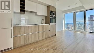 Toronto (Church-Yonge Corridor) condo for rent - A kitchen with wooden cabinets and a view of the city.