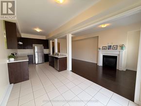 Bradford West Gwillimbury (Bradford) townhouse for rent - A well-lit, spacious kitchen and living room with a fireplace.