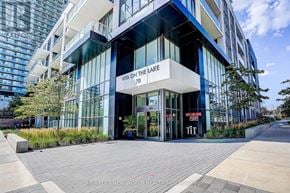 Toronto (Mimico) condo for rent - A modern building with a glass facade and a sign that reads "VIA ON THE LAKE 70".