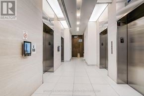 Toronto (Mimico) condo for rent - A hallway with elevators and a flat screen TV on the wall.