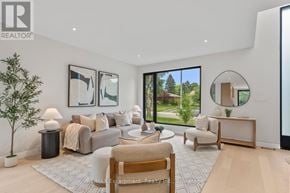 Burlington (Shoreacres) apartment for rent - A modern living room with a large window and a view of trees outside.