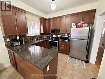 Whitby (Williamsburg) apartment for rent - A kitchen with brown cabinets and granite countertops.