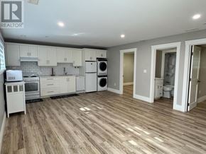 Saugeen Shores multi-family for rent - A kitchen with white appliances and wooden floors.