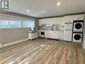 Saugeen Shores multi-family for rent - A kitchen with white appliances and wooden floors.