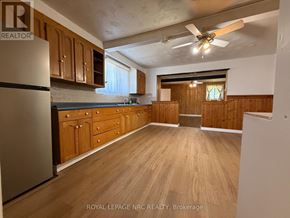 Niagara Falls (Ascot) apartment for rent - A kitchen with wooden cabinets and a refrigerator.