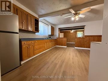 Niagara Falls (Ascot) apartment for rent - A kitchen with wooden cabinets and a refrigerator.