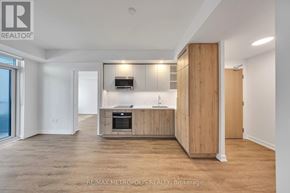 Vaughan (Vaughan Corporate Centre) condo for rent - A spacious, well-lit kitchen with wooden cabinets and a built-in oven.