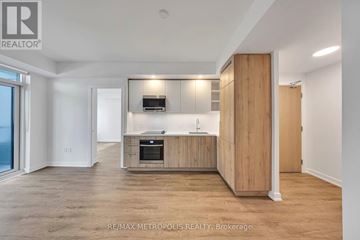 Vaughan (Vaughan Corporate Centre) condo for rent - A spacious, well-lit kitchen with wooden cabinets and a built-in oven.
