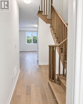 Haldimand townhouse for rent - A wooden staircase in a home leads to a bright room with a window.