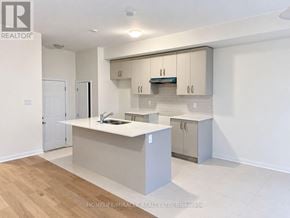 Haldimand townhouse for rent - A modern kitchen with white cabinets and a wooden floor.
