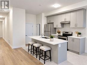Haldimand townhouse for rent - A kitchen with a white countertop and bar stools.