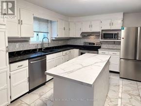 Quinte West (Trenton Ward) apartment for rent - A kitchen with white cabinets and a marble island.