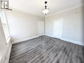 London East (East K) multi-family for rent - A room with a grey floor and white walls.
