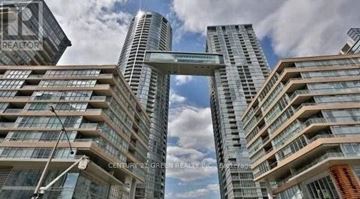 Toronto (Waterfront Communities) condo for rent - A real estate company's sign is superimposed on a photo of a cityscape with tall buildings.