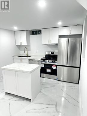 Whitby (Williamsburg) apartment for rent - A modern kitchen with white cabinets and marble flooring.