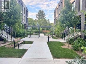 Toronto (Birchcliffe-Cliffside) townhouse for rent - A walkway with benches and trees in front of apartment buildings.