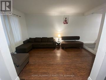 Brampton (Heart Lake West) apartment for rent - A living room with a grey sofa and a wooden floor.
