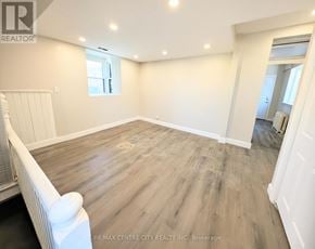 London East (East K) multi-family for rent - A spacious room with wooden flooring and white walls.