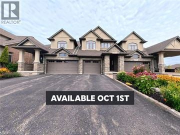 Waterloo townhouse for rent - A large, luxurious house with a driveway and the text "AVAILABLE OCT 1ST" on the front.