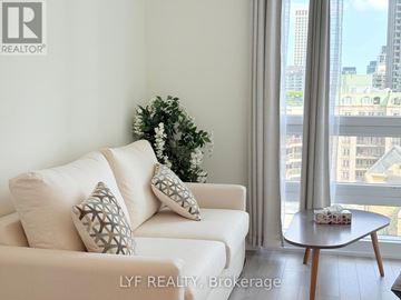 Toronto (Church-Yonge Corridor) condo for rent - A living room with a white couch and a green plant.