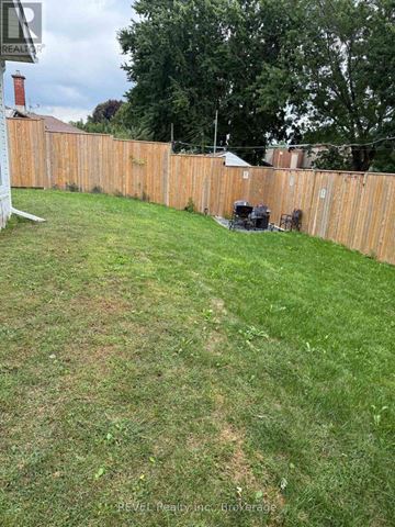 Niagara Falls (Cherrywood) apartment for rent - A backyard with a wooden fence and a lawn.