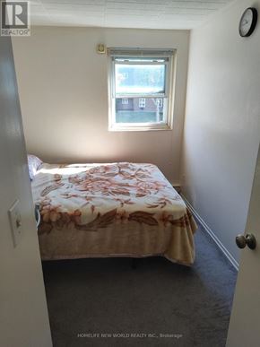 Windsor condo for rent - A bedroom with a bed, carpet, and a window.