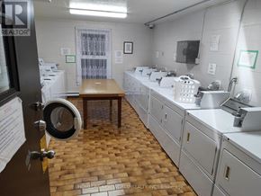 Windsor condo for rent - A room with white cabinets and a brown table in the middle.